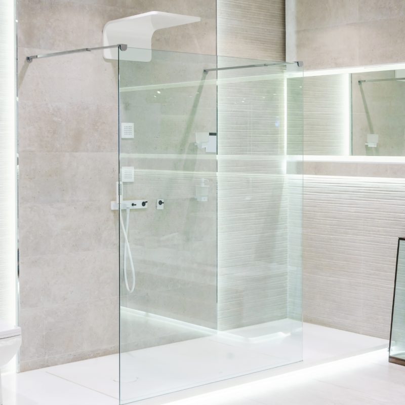 Bathroom interior with white walls, a shower cabin with glass wall, a toilet and sink