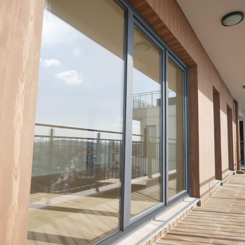 Spacious apartment balcony with wooden decking, glass sliding doors, and great natural light